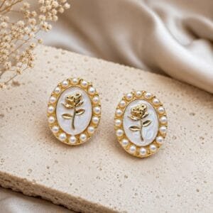 Vintage rosette stud earrings with golden rose design and pearl detailing